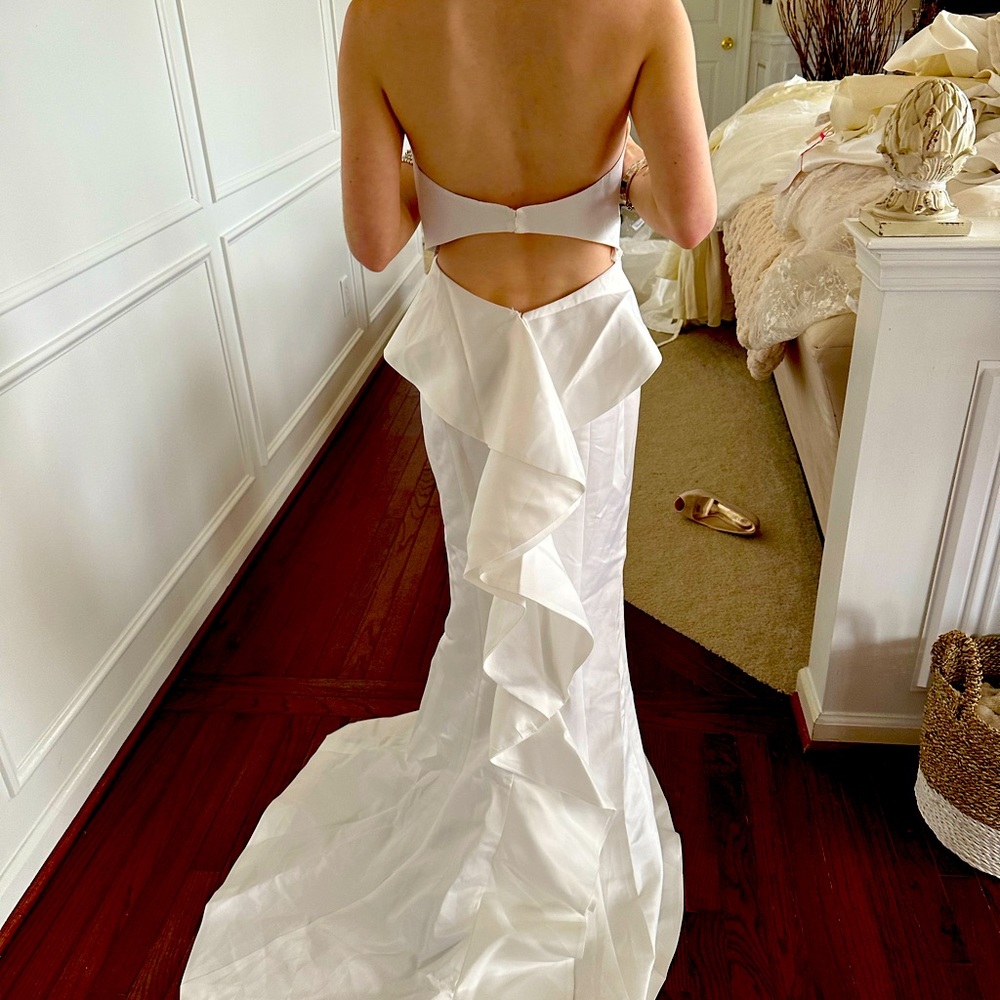 Strapless white satin wedding gown with ruffle down the back